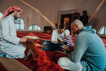 A group of Muslims reading the holy book of the Quran in a modern mosque during the Muslim holiday of Ramadan