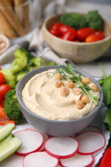 Plate with delicious hummus and fresh vegetables on table