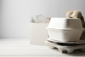 Heap of waste paper on white wooden table, space for text