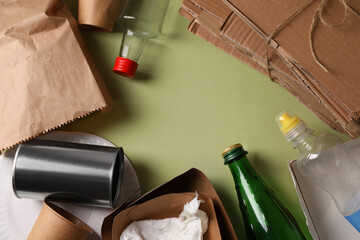 Frame of waste paper and other garbage on pale green background, flat lay. Space for text