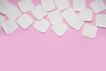Many clean cotton pads on pink background, flat lay. Space for text