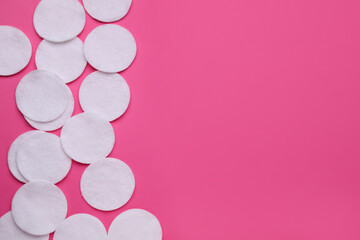 Clean cotton pads on pink background, flat lay. Space for text