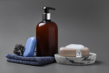 Obraz na płótnie Canvas Soap bar, bottle dispenser and towel on grey background