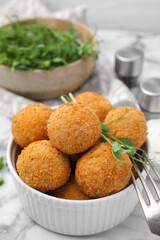 Bowl of delicious fried tofu balls with pea sprouts on white marble table, closeup