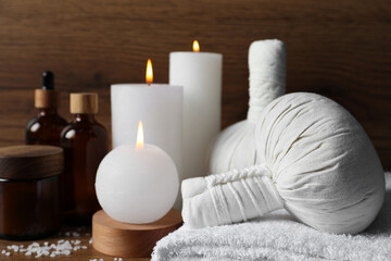Obraz na płótnie Canvas Beautiful spa composition with different care products and burning candles on wooden table, closeup. Space for text