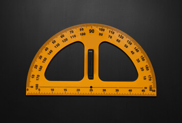Yellow school protractor on blackboard, top view