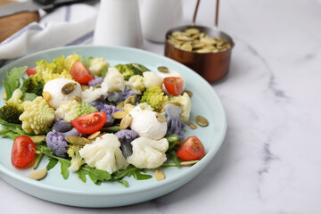 Delicious salad with cauliflower, tomato and cheese served on white marble table. Space for text