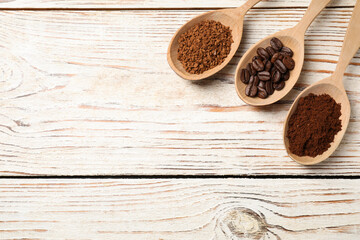 Spoons with instant, ground coffee and roasted beans on white wooden table, flat lay. Space for text