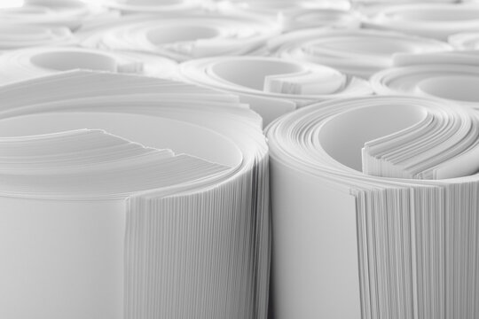 Rolled white paper sheets as background, closeup
