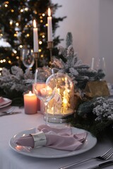 Beautiful festive place setting with Christmas decor on table indoors