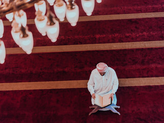 A Muslim reads the holy Islamic book Quraqn in a modern grand mosque during the Muslim holy month...