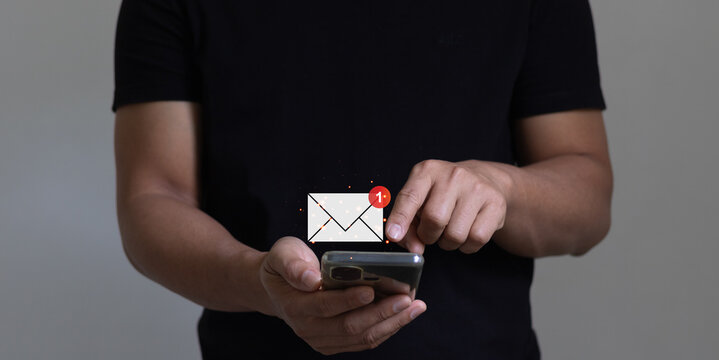 email marketing and online communication concept. businessman using smartphone for checking email online on web with virtual interface technology with 1 new email notification alert.