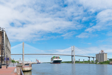 A barge passes under a suspension bridge on its way out to sea.