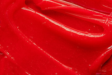 Red gel texture. Cosmetic clear liquid cream smudge. Skin care product sample closeup. Toothpaste...