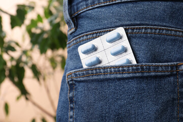 Jeans with pills in pocket, closeup. Potency problem