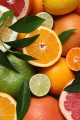 Different fresh whole and cut citrus fruits as background
