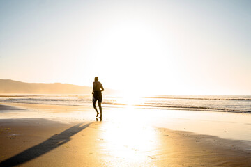 Fototapeta na wymiar runner on the beach at sunset
