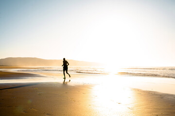 Fototapeta na wymiar runner on the beach at sunset