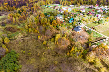 Fototapeta na wymiar Aerial view of a village surrounded by wild nature and colorful autumn landscape
