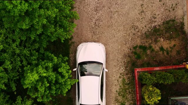 Medium Aerial Drone Shot Of White Car Arriving Home Down Driveway