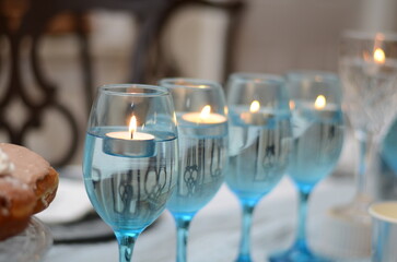 elegant row of  champagne glasses with floating candles on festive holiday table
