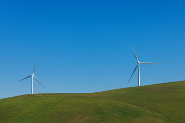 Wind turbines on the green meadow, renewable energy