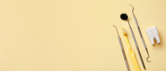 Brush, plastic tooth and dental tools on beige background with space for text