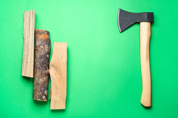 Frame made of ax and firewood on green background