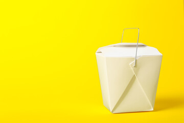 Paper box with Asian food on color background