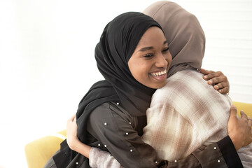 Multi racial Muslim woman in traditional hijab showing traditional Muslim greeting hug, Salam, As-salamu alaykum, Peace be upon you,