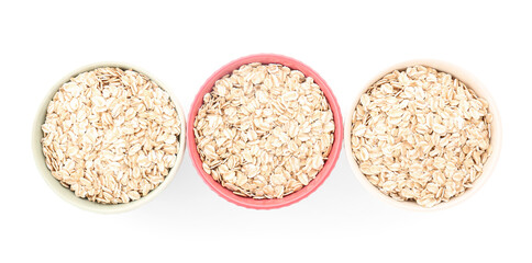 Bowls of raw oatmeal on white background