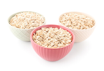 Bowls of raw oatmeal on white background
