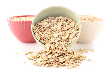 Bowls of raw oatmeal isolated on white background, closeup