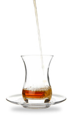 Pouring of Turkish tea into glass on white background
