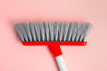 Cleaning broom on pink background, closeup