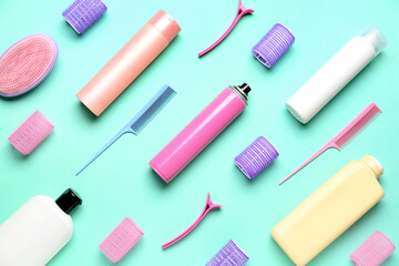 Hair care products with combs, curlers and clips on green background