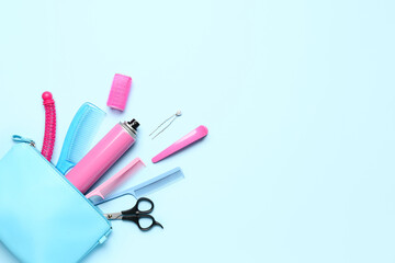 Bag with hair spray, combs, clips and scissors on blue background