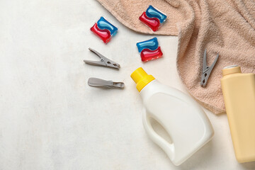 Laundry detergents, clothespins and towel on white background