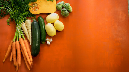 Dutch carrots, parsnips, brussel sprouts, zucchini, squash on a black surface
