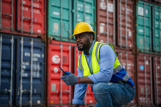 Engineer using walkie talkie checking stock into container for loading,International shipping logistics. - Powered by Adobe