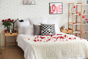 Interior of light bedroom decorated for Valentine's Day with roses, hearts and tables