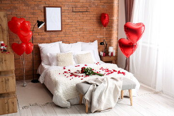 Interior of bedroom decorated for Valentine's Day with roses, frame and balloons