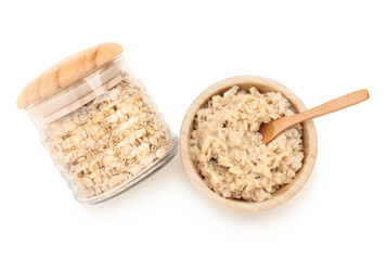 Wooden bowl of tasty oatmeal and jar with flakes isolated on white background