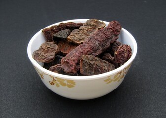 Dried Acacia concinna or Shikakai in a bowl on black background 