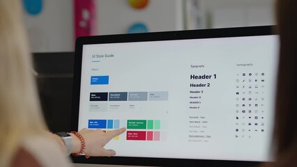 Corporate graphic designer coworkers look at a font and color branding sheet on a computer screen pointing to the best choices. - Powered by Adobe
