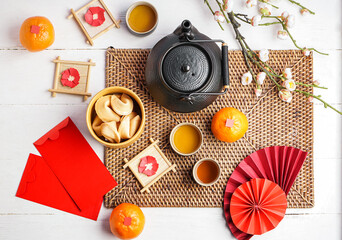 Teapot, fortune cookies, mandarins, envelopes and Chinese symbols on white wooden table. New Year celebration