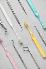 Dental tools with toothbrushes on grey background