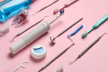 Dental tools with toothbrushes on pink background, closeup