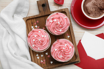Board with cupcakes, cup of coffee and envelope for Valentine's Day on wooden background