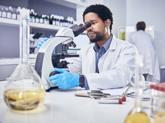 Microscope, scientist and black man with research, healthcare and diagnosis in laboratory. Science,...